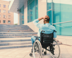 Rollstuhlfahrer steht ratlos vor Treppe